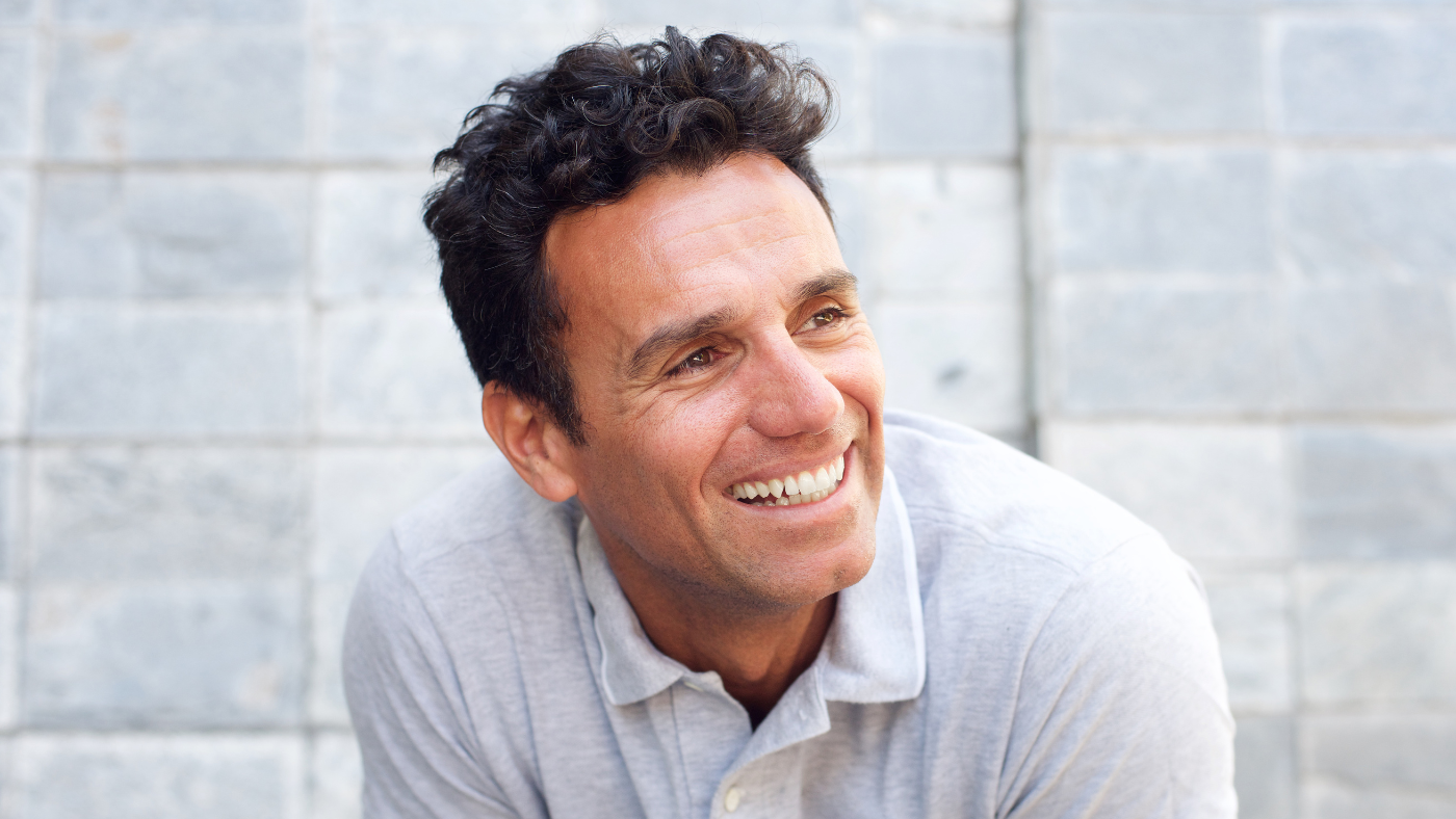 Man Laughing and leaning against wall