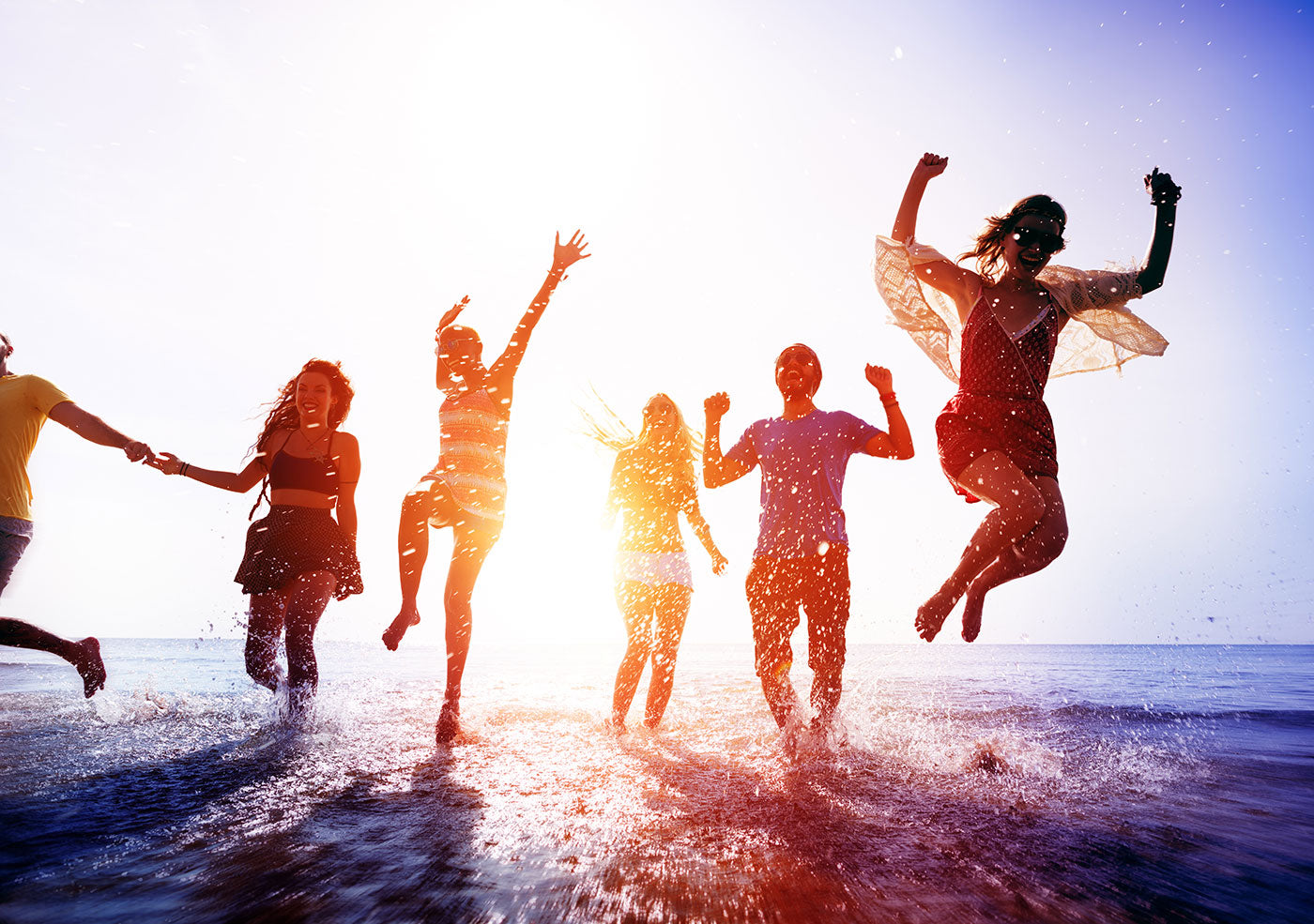 Young energetic people jumping at beach