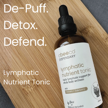Bottle of Lymphatic Nutrient Tonic on a wooden surface with text indicating benefits.
