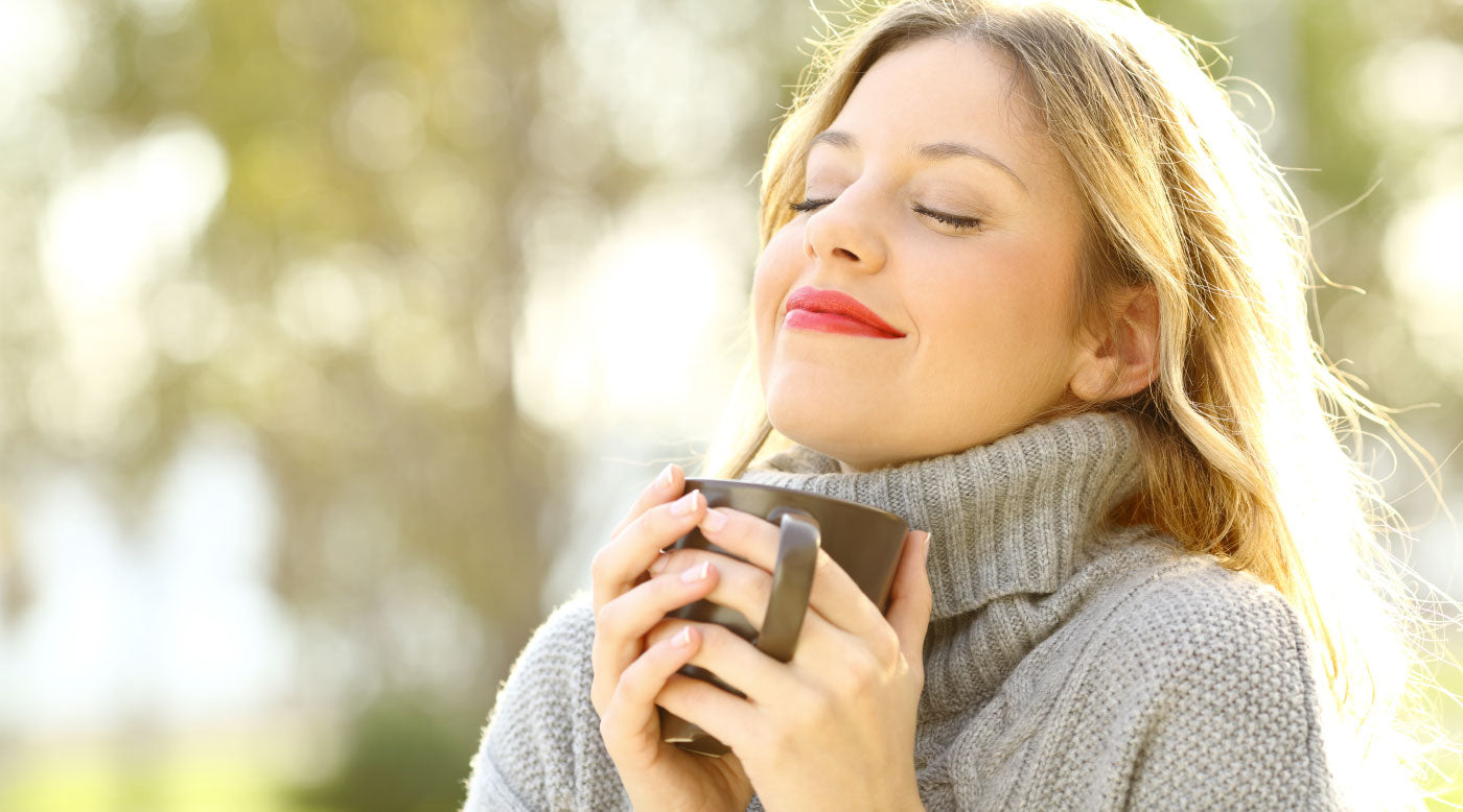 Young healthy woman enjoying the winter sunshine enjoying a hot drink