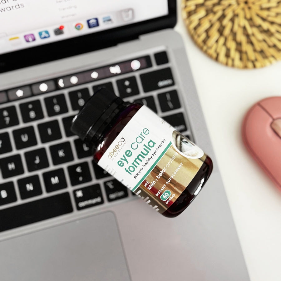 Eye care formula bottle on a laptop keyboard with a blurred background
