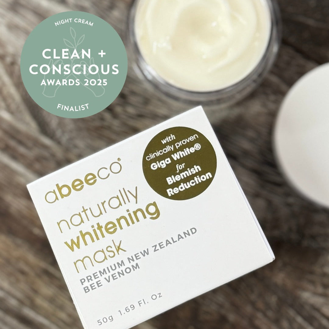 Abeeco naturally whitening mask packaging with a jar of cream on a wooden surface, featuring Clean + Conscious Awards 2025 finalist badge.