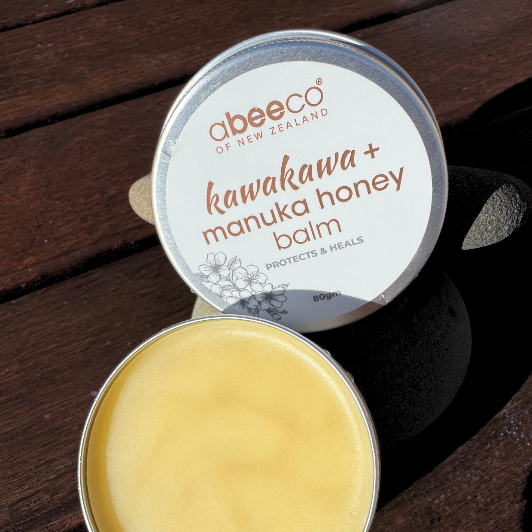 Abeeco kawakawa + manuka honey balm tin on a wooden surface