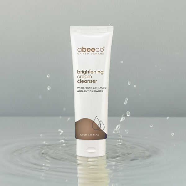 Tube of abeeco brightening cream cleanser on a gray background with water droplets.